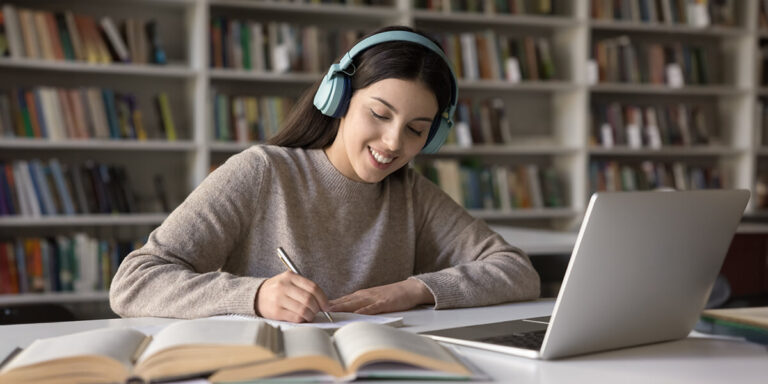 menina estudando com fone de ouvido na biblioteca