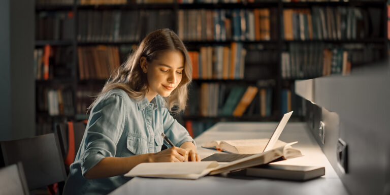 menina estudando de noite na biblioteca