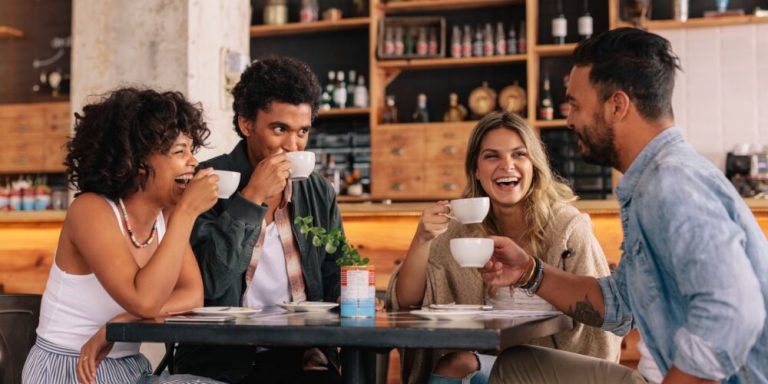 Amigos se divertindo em café, rindo e tomando café