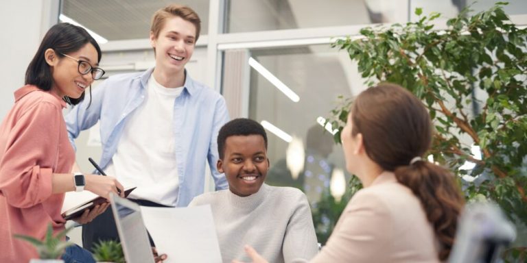 Grupo diverso discutindo em ambiente de trabalho moderno.