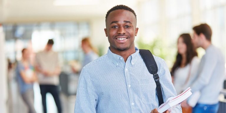 Estudante sorridente segurando livros em escola