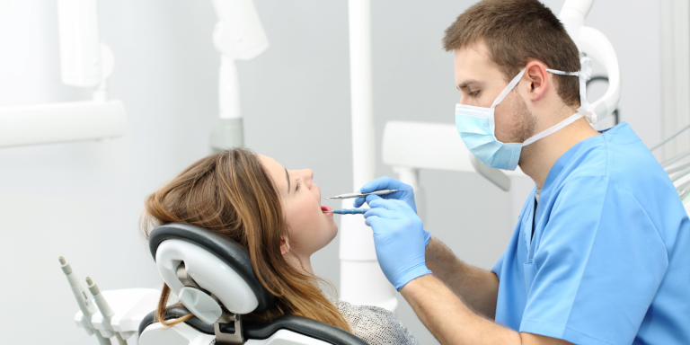 Dentista atendendo paciente no consultório odontológico