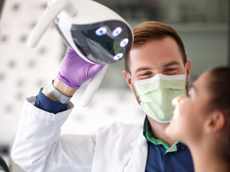 Dentista realizando exame em paciente sorridente