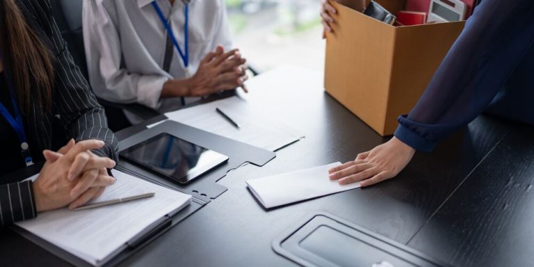 Pessoas em reunião com documentos e uma caixa de arquivos.