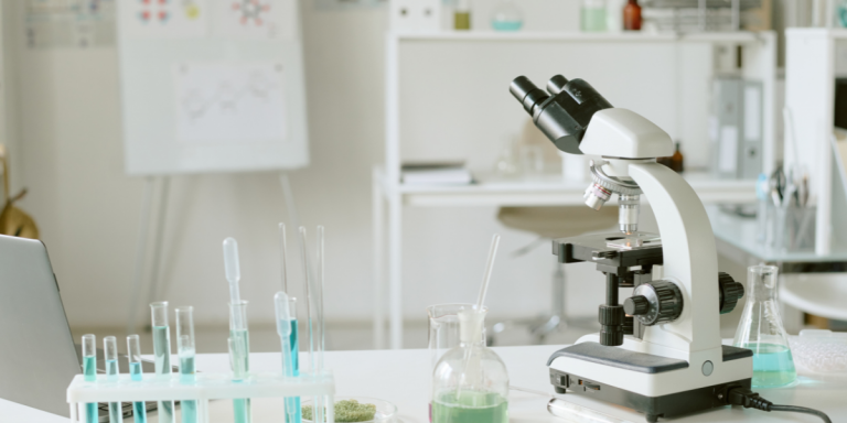 Mesa de laboratório com microscópio e tubos de ensaio